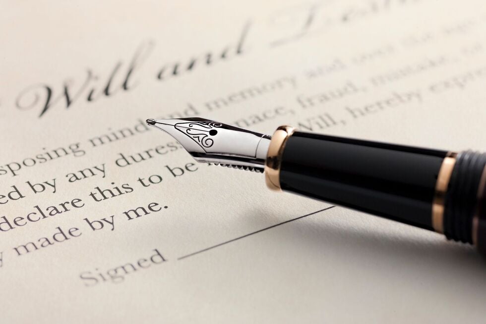 A fountain pen is sitting on top of a will and testament