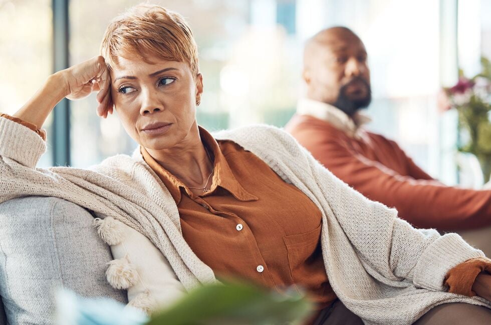A woman is sitting on a couch next to a man.
