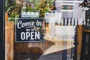 come in we're open sign on glass door