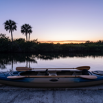A tandem kayak with two paddles on a Matlacha canal seawall at dusk, representing estate planning for married couples in Florida