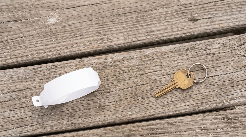 Hospital wristband and a house key on a Southwest Florida dock, representing medical and property decisions