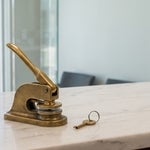 Brass embossing seal press and a safe deposit key on a bank counter in Fort Myers, representing letters of administration in Florida