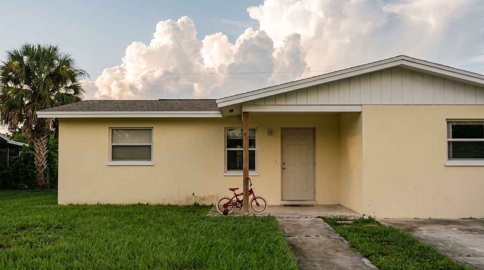 Child’s bicycle leaning on the front porch of a Bonita Springs home, representing the minor child who makes a Florida homestead impossible to devise