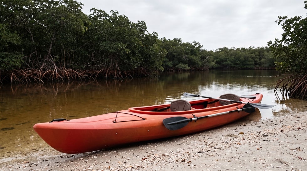Empty tandem kayak at a Naples mangrove launch with the rear paddle ready, representing an agent acting for a principal under a Florida durable power of attorney