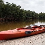 Empty tandem kayak at a Naples mangrove launch with the rear paddle ready, representing an agent acting for a principal under a Florida durable power of attorney