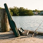 An adult fishing rod left in its closed case beside a child’s rigged rod on a Matlacha dock, representing an inheritance refused so it passes to the next generation