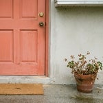 New brass deadbolt installed above an old lock on a Port Charlotte front door, with the old house key left on the doormat