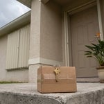 A house key resting on a shipping box on the front step of a shuttered Estero villa, representing an inherited Florida home managed by heirs who live out of state