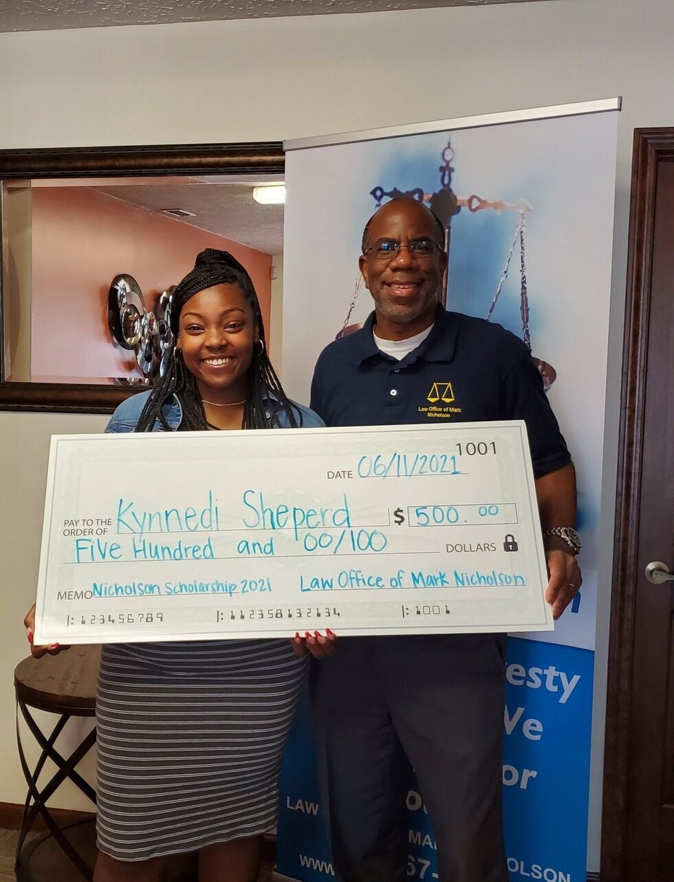 Attorney Mark Nicholson handing a Nicholson Scholarship to Kynnedi Shepherd