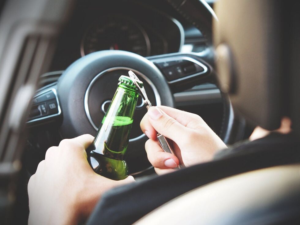 A Woman in Car Opening a Bottle of Beer
