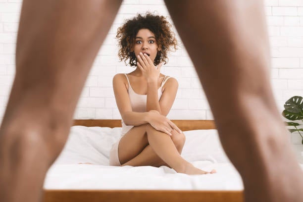 Man flashing woman while she is in bed
