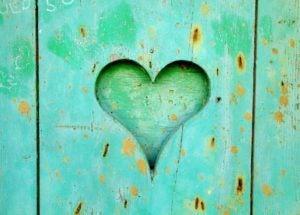 Green wooden board with a carved heart.