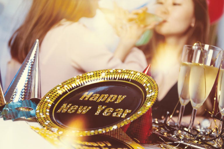 A New Year's Eve party, two women drinking, alcohol and decorations.