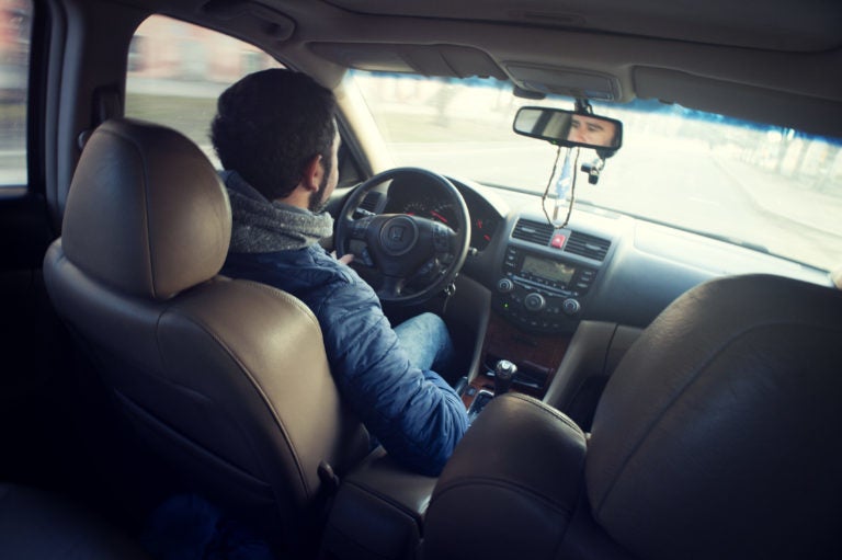 Man inside car, driving.