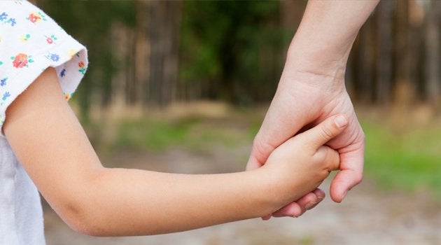 Parent holding hands with a child